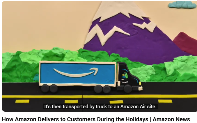 A still from the video commercial, showing a modelling clay truck on a road with green & snow capped mountains, also all in colored modelling clay from 'How Amazon Delivers to Customers During the Holidays' Amazon News - a WM Cline Commercial Voiceover