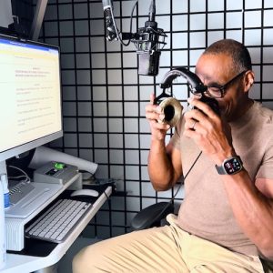 Voice over artist and narrator William Marshall Cline taking off his headphones in his home recording studio